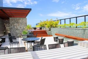 a patio with a table and chairs and a table and benches at Ocean Art Park - By Living in João Pessoa +239 photos