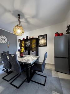 a dining room with a table and chairs and a refrigerator at Apartman Nonno Božo 2 in Fažana