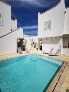 una piscina en el patio trasero de una casa con edificios blancos en Borgo Celentano, en Torre Lapillo