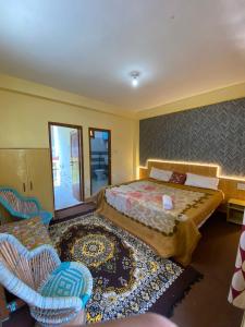 una camera da letto con un letto e due sedie di Hostello Manali a Manāli