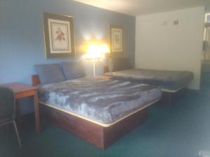 a bedroom with two beds and a table and a lamp at King Bed Hotel Studio 102 in Livingston +6 photos