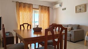 ein Esszimmer mit Tisch und Couch in der Unterkunft Nautic Vista Mar - Apartment in Armação de Pêra