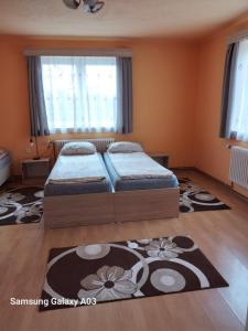 una camera da letto con due letti e un tappeto di Timi Kulcsosház a Lăzarea