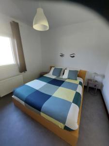 a bedroom with a blue and white bed and a window at La Casa Bianca in Lierneux