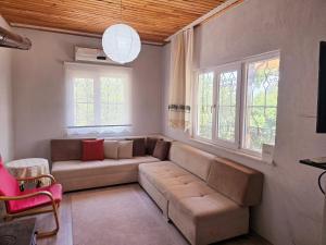 a living room with a couch and two windows at Olympos Orange Village Nature, Sea and You in Kumluca