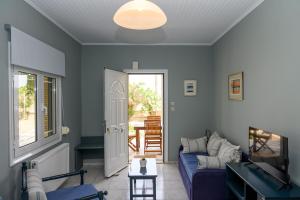 a living room with a blue couch and a table at Ocean Melody in Megás Limniónas