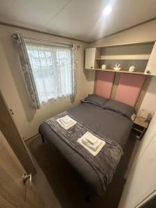 a small bedroom with a bed and a window at 8 Birth Holiday Home in Selsey +3 photos