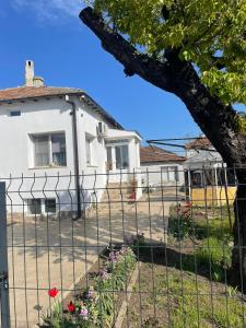 a fence in front of a white house at Къща за гости НИКА in Kavarna