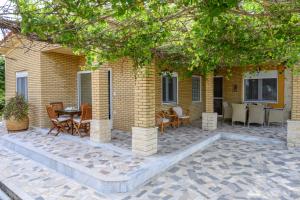 a patio with a table and chairs and a building at Ocean Melody in Megás Limniónas