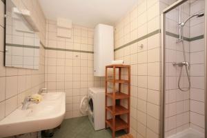 a bathroom with a sink and a toilet and a shower at Zeller City Apartment Aydin in Zell am See