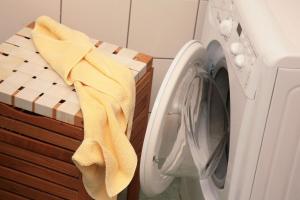 a washing machine with a yellow towel next to a washer at Zeller City Apartment Aydin in Zell am See
