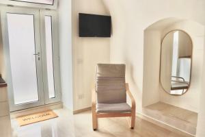 a chair sitting in a room with a mirror at Ringo Suites in Grumo Appula