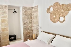 a bedroom with a bed and a stone wall at Ringo Suites in Grumo Appula