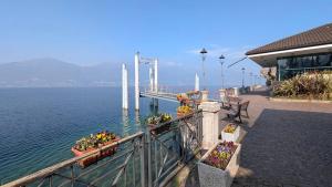 ein Pier mit Blumen darauf neben dem Wasser in der Unterkunft Ca Del Lac in Porto Valtravaglia
