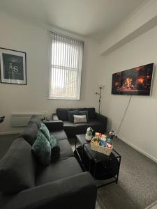 a living room with a couch and a tv at City Haven - 2 Bed in Sheffield - LuxeSuites in Midland