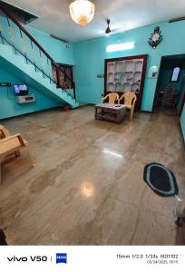 a living room with blue walls and a staircase at R & P Heritage Stay in Madurai