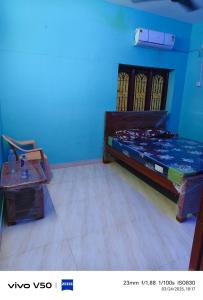 a bedroom with a bed and a table in a room at R & P Heritage Stay in Madurai +4 photos