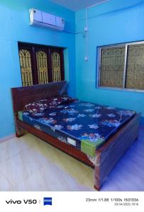 a bed in a room with a blue wall at R & P Heritage Stay in Madurai