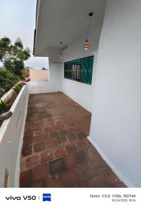 a staircase leading up to a white wall with a brick floor at R & P Heritage Stay in Madurai