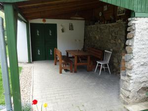 a patio with a table and chairs and a green door at Penzion Na Třeťasu s vinným sklepem in Starovice