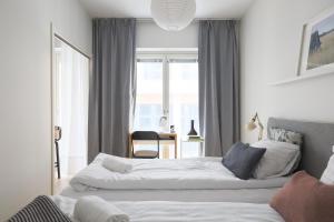 a bedroom with two beds and a desk in it at Fredika, modern 1br,Tripla Pasila prime location, gym, parking, train station near in Helsinki +27 photos