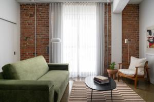 a living room with a green couch and a table at Maison Sainte-Thérèse By Maisons & co in Montréal