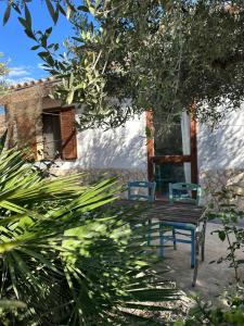 a bench and two chairs in front of a house at La Gallinaia room with bathroom in Cartabubbo