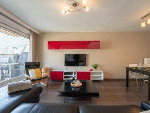 a living room with red cabinets and a flat screen tv at Apartment Ter Duyne by Interhome in Bredene +18 photos