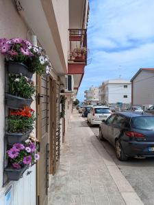 a street with flowers on the side of a building at La casetta di Clary in Polignano a Mare