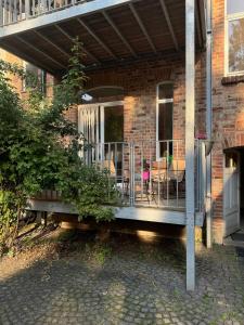 a porch of a brick house with chairs and tables at 1-Zimmer-Apartment mit Balkon nähe ICE-Bahnhof in Kassel