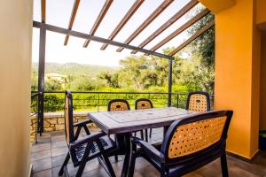 einen Tisch und Stühle auf einem Balkon mit Aussicht in der Unterkunft Villas Gregory in Syvota