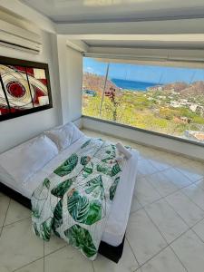 ein Schlafzimmer mit einem Bett und einem großen Fenster in der Unterkunft Casa Relax - Adults Only in Taganga