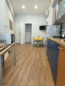 una cucina con pavimenti in legno e un tavolo giallo di Canfora 163 Cutaias apartment a Catania