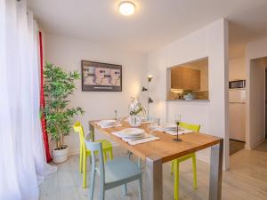 una sala da pranzo con tavolo in legno e sedie gialle di Apartment Le Christina by Interhome a Sainte-Maxime Altre 18 foto