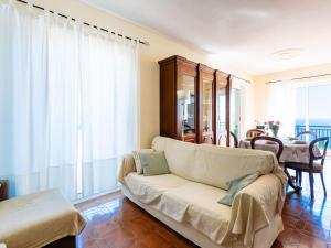 a living room with a couch and a table at Holiday Home Casa Cycas by Interhome in Ospedaletti