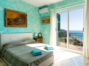 a bedroom with a bed and a view of the ocean at Holiday Home Casa Cycas by Interhome in Ospedaletti