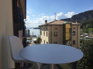 einen weißen Tisch und einen Stuhl auf einem Balkon mit Aussicht in der Unterkunft Hotel Miro' in Garda