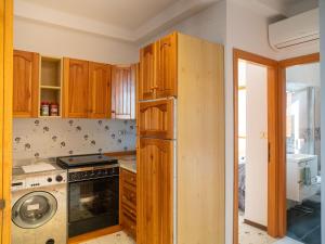 eine Küche mit Holzschränken, einer Waschmaschine und einem Trockner in der Unterkunft Apartment Vasto Sea View by Interhome in Vasto