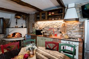 a kitchen with a table and a stove with a fireplace at Вила Китна in Lozno