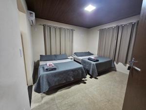 a bedroom with two beds and a window at Hospedagem Costa BNU - Q1 in Blumenau