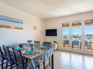 a dining room with a table and chairs and a balcony at Apartment Lou Gangui by Interhome in Carqueiranne