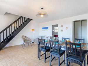 a dining room with a table and chairs and a staircase at Apartment Lou Gangui by Interhome in Carqueiranne