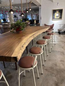 Una larga barra de madera con taburetes alrededor. en Don Hostel, en Villavicencio