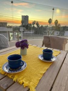 a table with two blue cups and a yellow napkin at New! Lovely and spacious, 2 Ocean view terraces in El Suazal