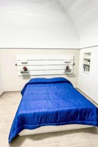 a bed in a white room with a blue blanket at Apartment Il Balconcino di Sorrento by Interhome in Sorrento +5 photos