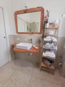 un bagno con lavandino, specchio e asciugamani di "Nonna Maria" a Venegono Superiore