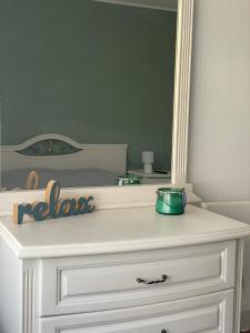 a white dresser with a mirror on top of it at Къща за гости НИКА in Kavarna +19 photos