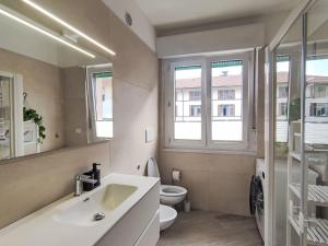a bathroom with a sink and a toilet and windows at Apartment Nonnellini by Interhome in Trento
