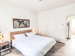 a white bedroom with a large bed and a table at Apartment Nonnellini by Interhome in Trento +12 photos