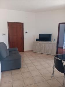 a living room with a blue couch and a television at Lovely house tra pineta e mare in Torre di Montalto